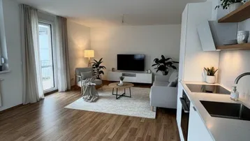 Moderner offener Wohnbereich mit integrierter Küche, Holzboden und Zugang zum Balkon.