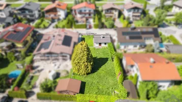 Luftaufnahme eines Grundstücks mit Einfamilienhaus, Garten und Nebengebäude in Wohnsiedlung.