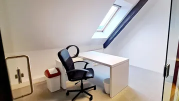 Helles Dachgeschossbüro mit modernem Schreibtisch, Bürostuhl und Dachfenster, ideal für konzentriertes Arbeiten.