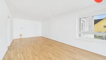 Geräumiges, leeres Wohnzimmer mit hellem Parkettboden und großem Fenster, ideal für individuelle Gestaltung.