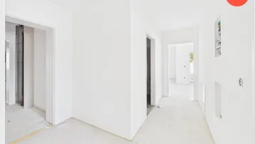 Heller, unfertiger Flur mit weißen Wänden und Rohbetonboden, bereit für den Innenausbau.