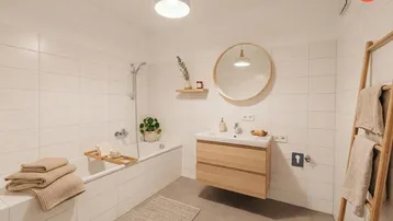 Helles Badezimmer mit Badewanne, modernem Waschtisch, großen weißen Fliesen und Holzdetails.