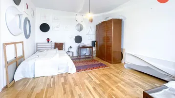 Helles Schlafzimmer mit Holzboden, einem Bett und einem großen Kleiderschrank.