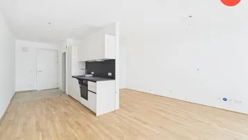 Heller offener Raum mit moderner Einbauküche und hellem Holzfußboden, bereit zum Einzug.