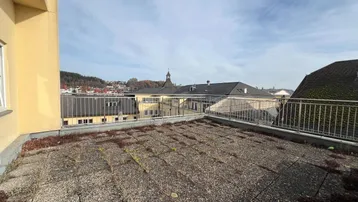 Große Dachterrasse mit Blick auf die Stadt und die umliegende Landschaft unter blauem Himmel.