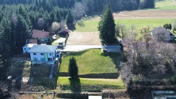 Luftaufnahme eines Grundstücks mit angrenzendem Wald und weiten Feldern in ländlicher Umgebung.