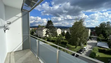 Geräumiger Balkon mit Glasgeländer und weitem Blick über die Umgebung.