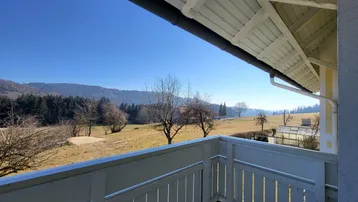 Balkon mit Holzboden und weitem Blick über die ländliche Landschaft und Wälder.