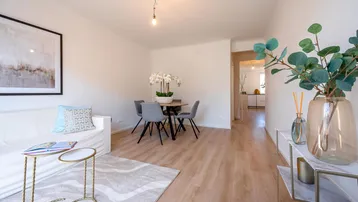Helles Wohn- und Esszimmer mit modernem Laminatboden und stilvoller Dekoration.