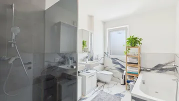 Modernes Badezimmer mit begehbarer Dusche, Badewanne und eleganten Marmorfliesen.