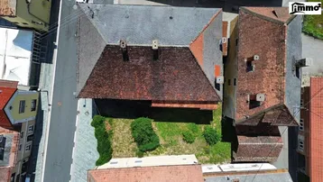 Luftaufnahme des Gebäudes mit Dach und angrenzendem Gartenbereich.