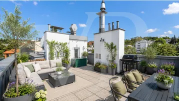 Große Dachterrasse mit bequemen Loungemöbeln, Grillbereich und weitem Blick über die Umgebung.