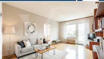 Helles Wohnzimmer mit Parkettboden, beiger Wandfarbe und Zugang zum Balkon.