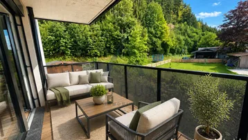 Geräumiger Balkon mit modernen Outdoor-Möbeln und Blick ins Grüne, ideal zum Entspannen.