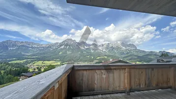Geräumiger Holzbalkon mit atemberaubendem Bergblick und viel natürlichem Licht.