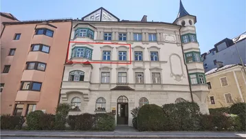 Historisches Gebäude mit eleganter Fassade und markanten Erkern in städtischer Umgebung.
