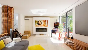 Helles Wohnzimmer mit Kamin, großen Fenstern und modernem Interieur.