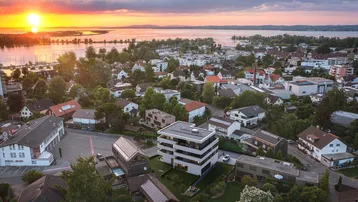Luftaufnahme der Wohngegend bei Sonnenuntergang mit Blick auf den See und die umliegenden Häuser.