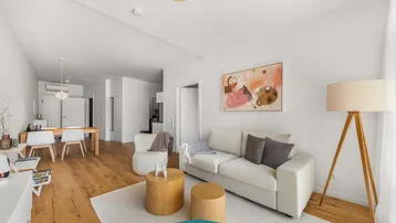 Geräumiger Wohn- und Essbereich mit bequemer Couch, Holzboden und moderner Einrichtung.
