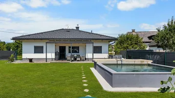 Modernes Haus mit großem Garten, Swimmingpool und überdachter Terrasse.