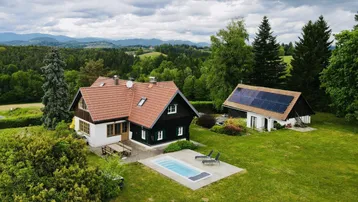 Panoramablick auf ein charmantes Landhaus mit Pool und separatem Gebäude mit Solaranlage.