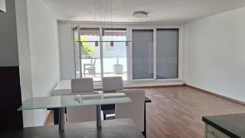Heller offener Wohn- und Essbereich mit Holzboden und Zugang zur Terrasse.