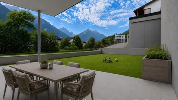 Moderne Terrasse mit stilvollen Gartenmöbeln, Blick auf einen gepflegten Rasen und die majestätische Berglandschaft.