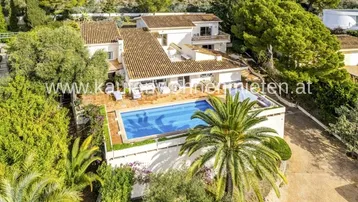 Luftaufnahme der Villa mit großem Poolbereich und mediterraner Umgebung.