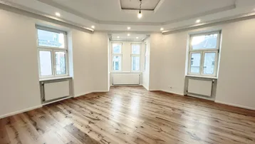 Helles, geräumiges Zimmer mit modernem Parkettboden, dekorativer Decke und Einbaustrahlern.