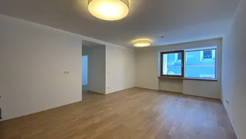 Helles, leeres Zimmer mit Parkettboden und großen Fenstern, bereit zur individuellen Gestaltung.