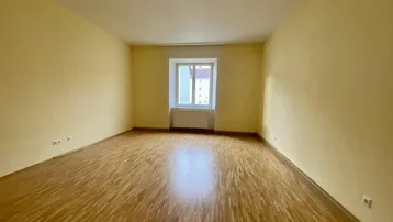 Heller Raum mit gelben Wänden und Parkettboden, ideal als Wohnzimmer nutzbar.