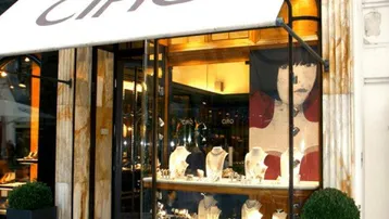 Die Fassade des Geschäfts mit einer Markise und Schaufenstern, die Schmuck ausstellen.
