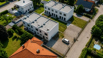 Luftaufnahme von modernen Reihenhäusern mit Flachdächern in einer Wohnsiedlung.