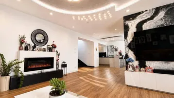 Modernes Wohnzimmer mit Kamin, Laminatboden und stilvoller Deckenbeleuchtung.