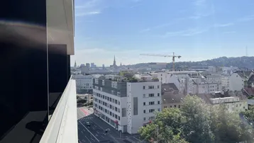 Stadtansicht von einem Balkon mit Blick auf Gebäude und den Himmel.
