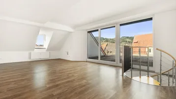 Helles Wohnzimmer mit Holzboden, Dachschrägen und Zugang zu einer großen Dachterrasse.