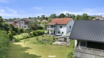 Luftaufnahme des Hauses mit großem Garten und umliegender grüner Landschaft.
