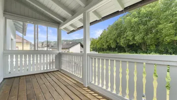 Heller Balkon mit Holzboden und schöner Aussicht auf die Umgebung.