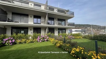 Moderne Wohnanlage mit gepflegtem Gartenbereich und blühenden Pflanzen vor den Terrassen.