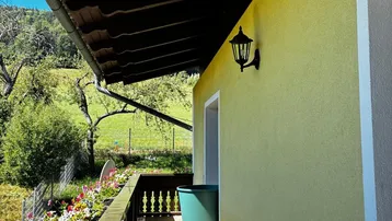 Geräumiger Balkon mit Fliesenboden, Holzbalkon und weitem Blick auf die grüne Landschaft.