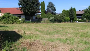 Großes, sonniges Grundstück mit Rasenfläche und Blick auf umliegende Wohnhäuser und viel Grün.