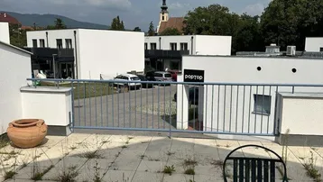 Terrasse mit Blick auf die Straße und einen Kirchturm in der Ferne.