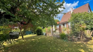 Großer, gepflegter Garten mit altem Baumbestand und viel Grünfläche hinter dem Haus.