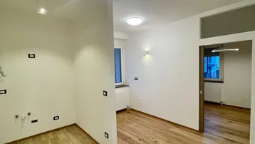 Heller, unmöblierter Raum mit Holzboden und modernen Lichtleisten, bereit für die individuelle Gestaltung.
