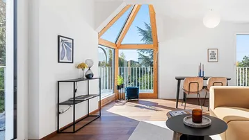 Heller Wohn- und Essbereich mit großen Fenstern, Holzboden und modernem Design.