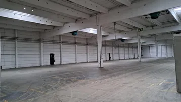 Große, leere Lagerhalle mit hohen Decken und Betonboden, bereit für die Nutzung.