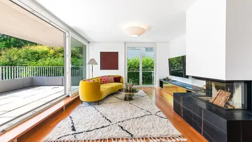 Helles Wohnzimmer mit modernem Kamin, gelbem Sofa und Zugang zur großen Terrasse.