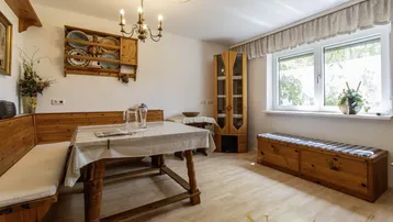 Rustikaler Essbereich mit Holzbänken, Esstisch und Fenster mit Blick ins Grüne.