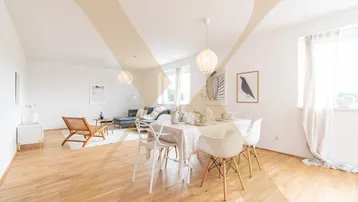 Helles, offenes Wohn- und Esszimmer mit Parkettboden und modernen Möbeln, ideal für geselliges Beisammensein.