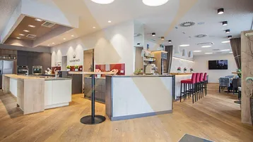 Geräumige, moderne Küche mit Holzboden und integriertem Essbereich, ideal für Veranstaltungen oder Gastronomie.